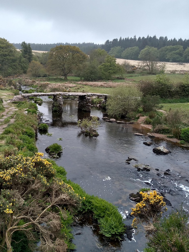 Stone bridge over a river under gray skies.