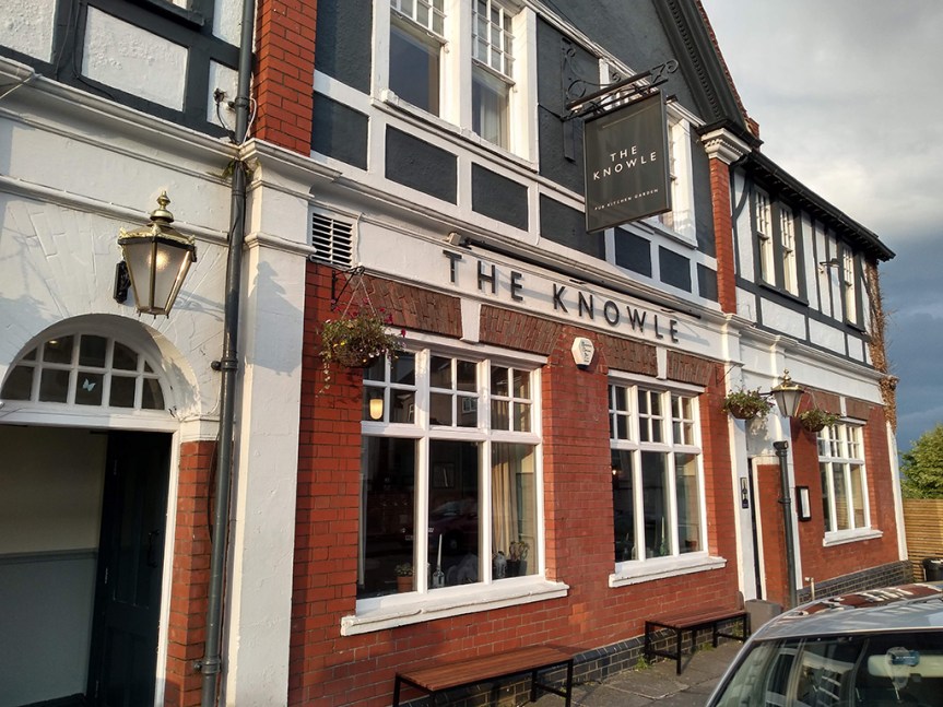 Pub building, red brick and white trim. Sign says "The Knowle".