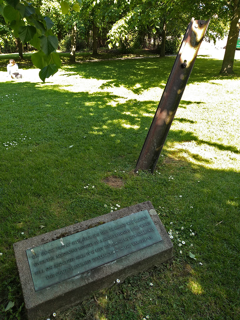 Memorial plaque and tramline (rail) section stuck in the ground behind it.